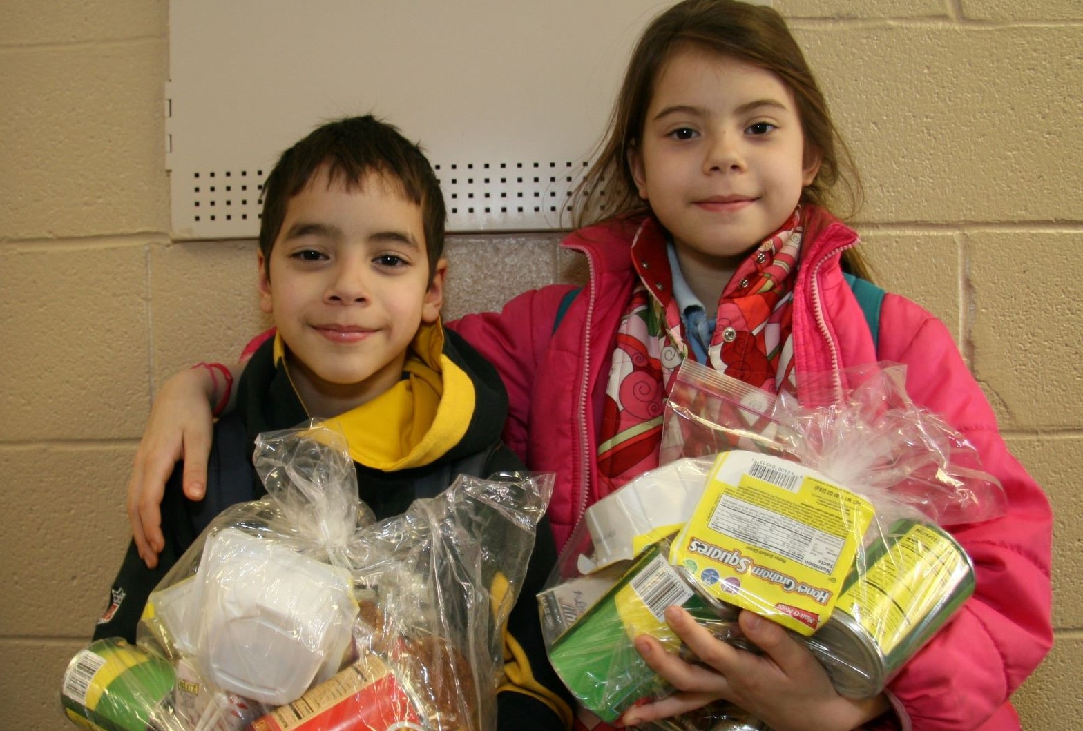 Kids receiving backpacks full of food
